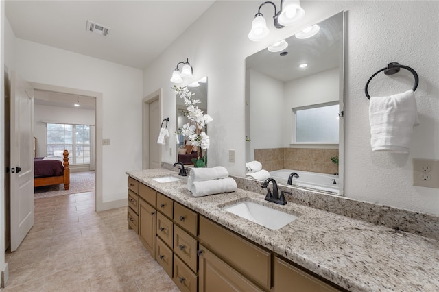 bathroom featuring tile patterned floors, vanity, and a bathing tub