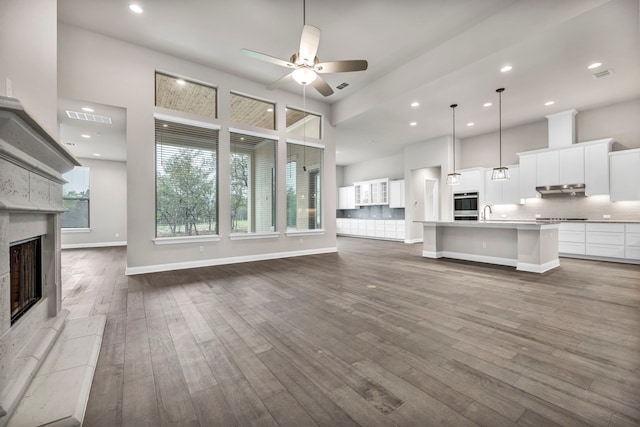 unfurnished living room featuring ceiling fan and wood-type flooring