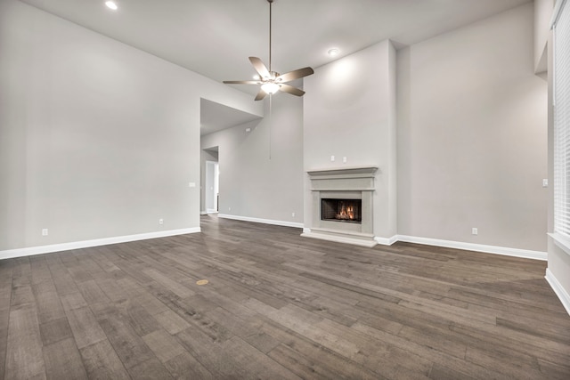 unfurnished living room featuring dark wood-type flooring, lofted ceiling, and ceiling fan