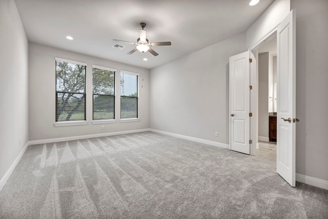 spare room with ceiling fan and light colored carpet