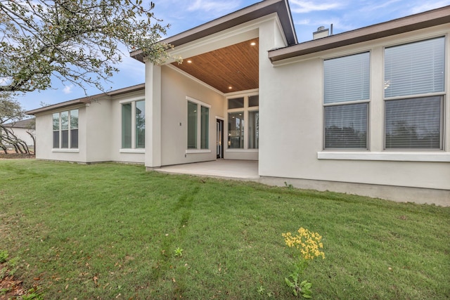 back of house with a patio area and a lawn