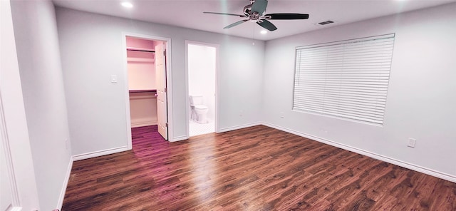 unfurnished bedroom with ensuite bathroom, ceiling fan, a closet, dark hardwood / wood-style flooring, and a walk in closet