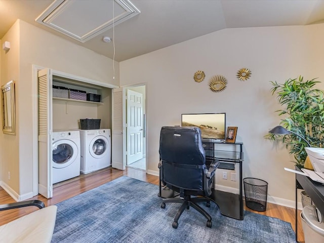 office area featuring hardwood / wood-style flooring, washer and clothes dryer, and vaulted ceiling