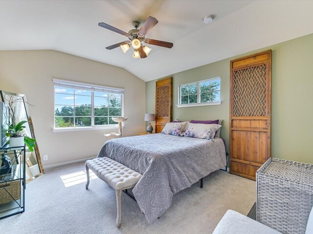 bedroom featuring light carpet, multiple windows, and vaulted ceiling