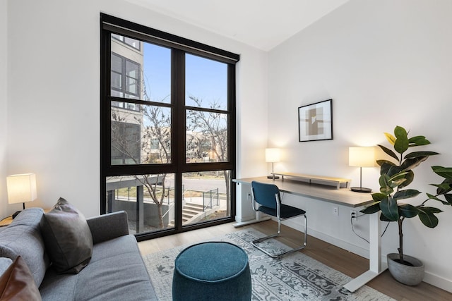 office space featuring built in desk, a wealth of natural light, and light hardwood / wood-style flooring