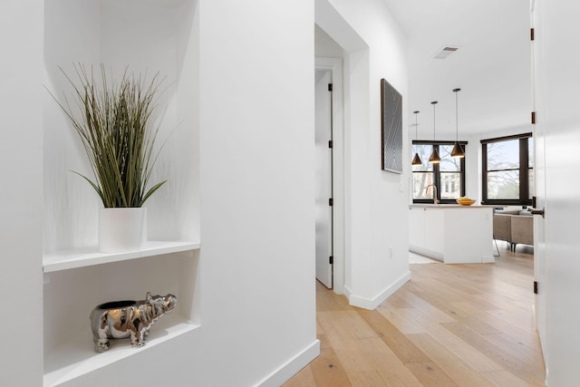 corridor featuring light hardwood / wood-style floors and sink