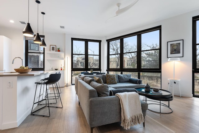 living room with sink and light hardwood / wood-style flooring