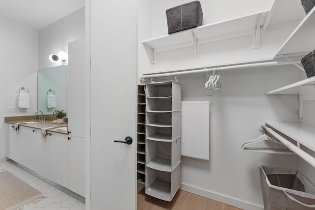 spacious closet with light wood-type flooring and sink