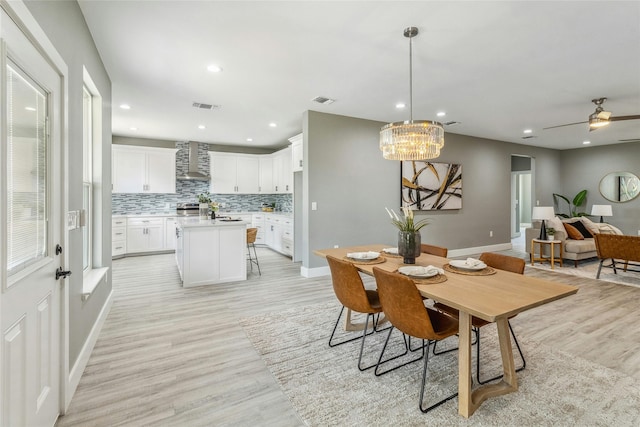 dining space with ceiling fan and light hardwood / wood-style flooring