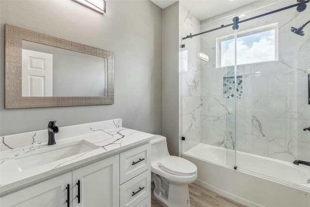 full bathroom featuring combined bath / shower with glass door, vanity, toilet, and hardwood / wood-style flooring