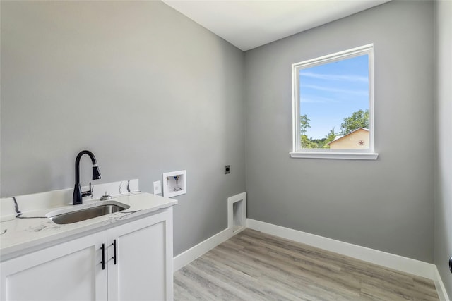 clothes washing area featuring sink, hookup for a washing machine, light hardwood / wood-style flooring, hookup for an electric dryer, and cabinets