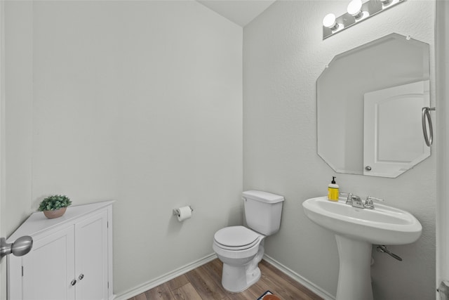 bathroom with hardwood / wood-style flooring and toilet