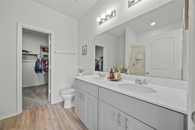 bathroom featuring toilet, walk in shower, and vanity