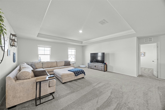 carpeted living room featuring a tray ceiling and ornamental molding