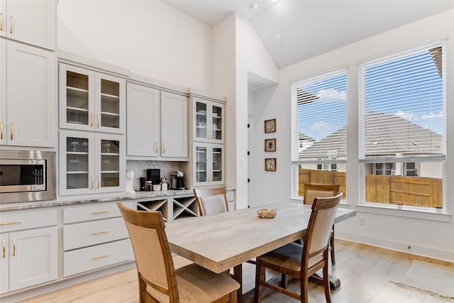 dining space with light hardwood / wood-style floors and lofted ceiling