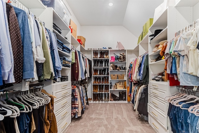 spacious closet with light carpet and vaulted ceiling