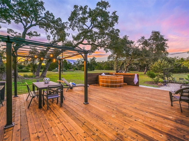 deck at dusk with a lawn and a pergola