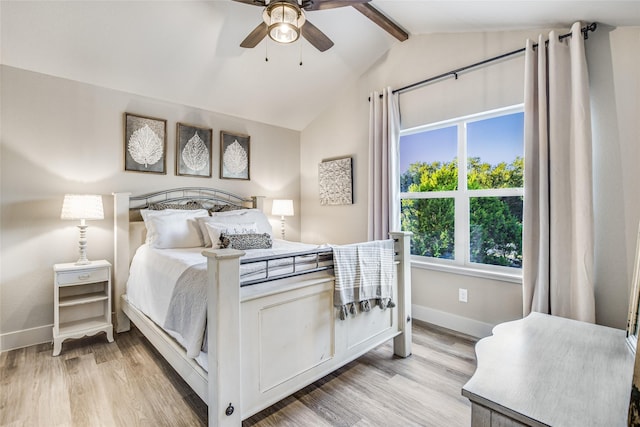 bedroom featuring light wood-type flooring, ceiling fan, and vaulted ceiling with beams