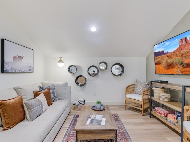 living room with light hardwood / wood-style floors and vaulted ceiling