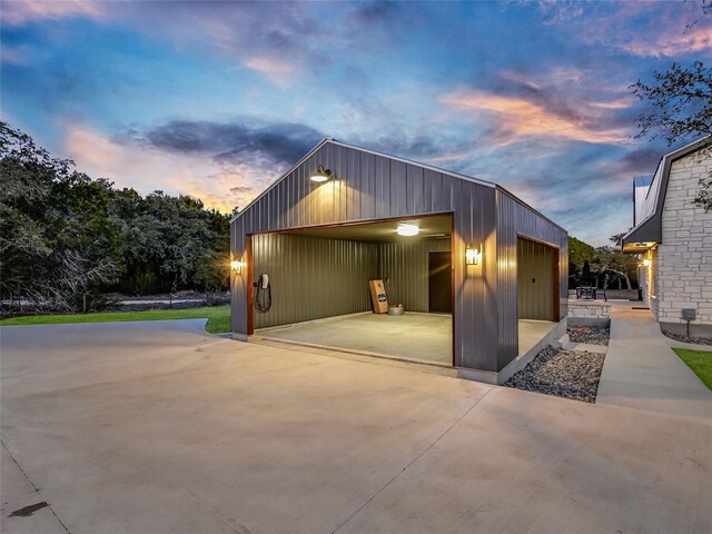 property exterior at dusk featuring a garage and an outbuilding