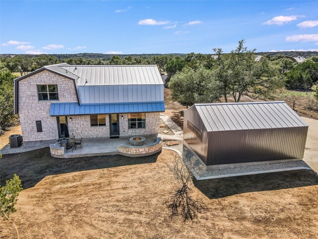 back of house featuring central air condition unit, a patio, and a fire pit