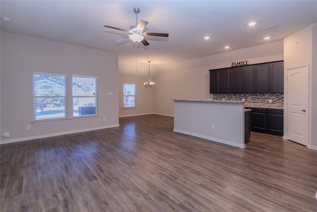 kitchen featuring decorative backsplash, dark wood-type flooring, decorative light fixtures, and ceiling fan with notable chandelier