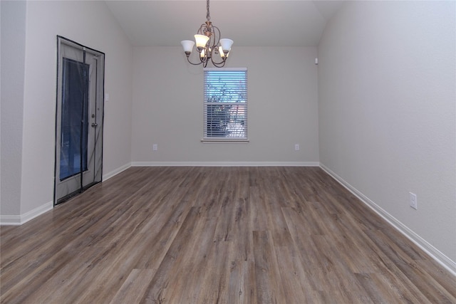 empty room with vaulted ceiling, dark hardwood / wood-style flooring, and a notable chandelier