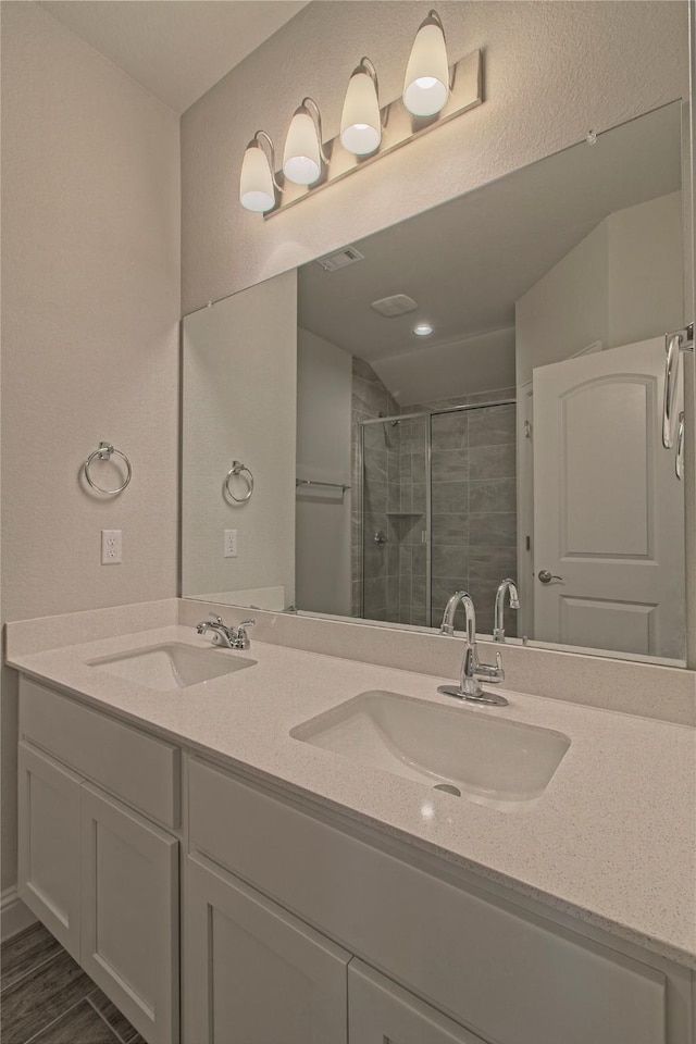 bathroom with a shower with door, wood-type flooring, and vanity