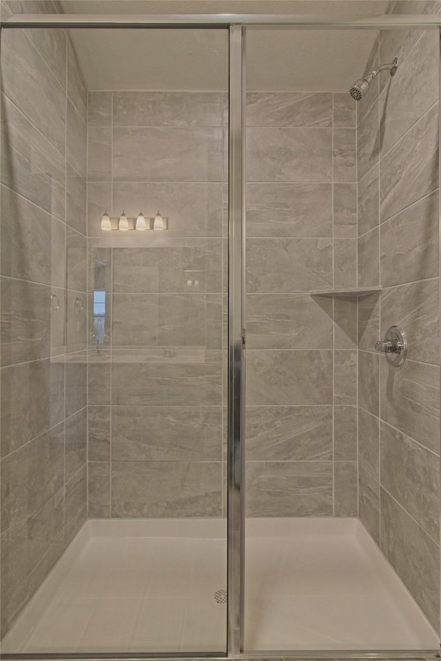 bathroom featuring a shower with door