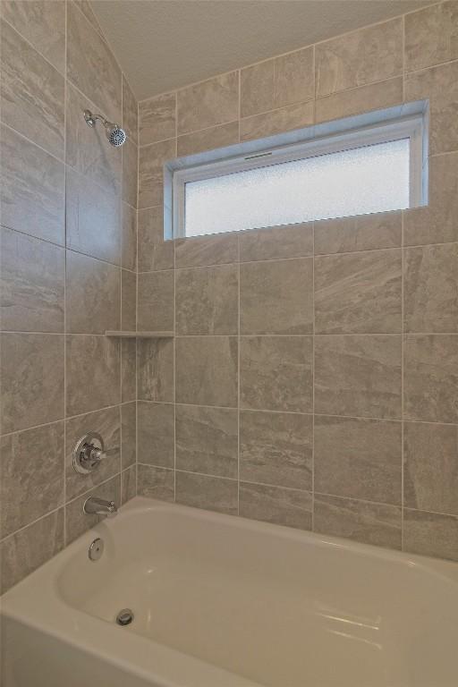 bathroom with plenty of natural light and tiled shower / bath combo