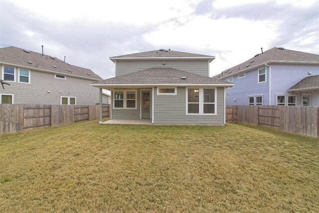 rear view of house with a patio and a yard