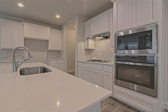 kitchen featuring sink, white cabinets, and built in microwave