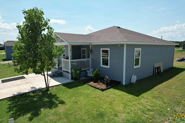 back of house with a lawn and covered porch