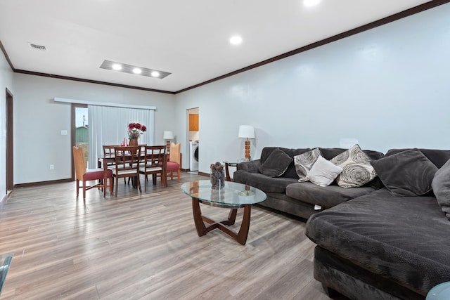 living room with washer / clothes dryer, light wood-type flooring, and ornamental molding