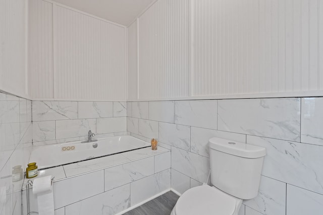 bathroom with tile walls and toilet