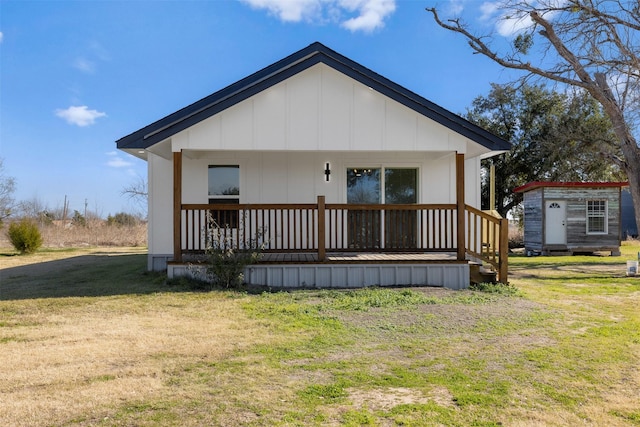 back of property with a porch and a yard