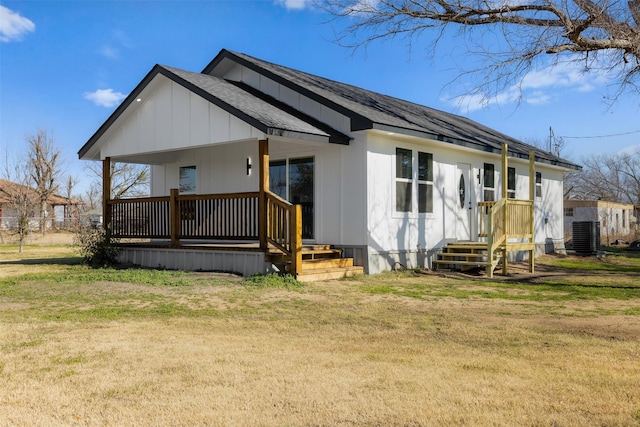 view of front facade with a front lawn, central air condition unit, and a porch