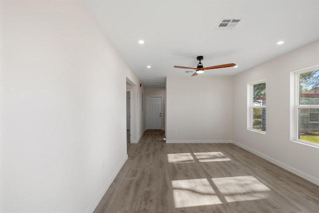 empty room with ceiling fan and light hardwood / wood-style flooring