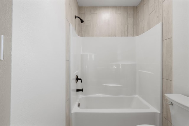 bathroom featuring bathtub / shower combination and toilet