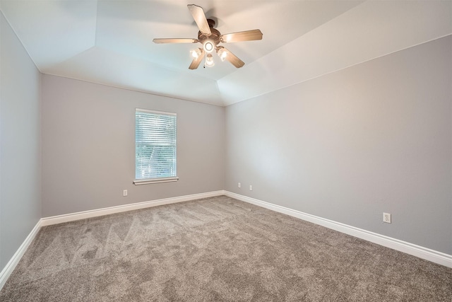 carpeted spare room featuring ceiling fan and a tray ceiling