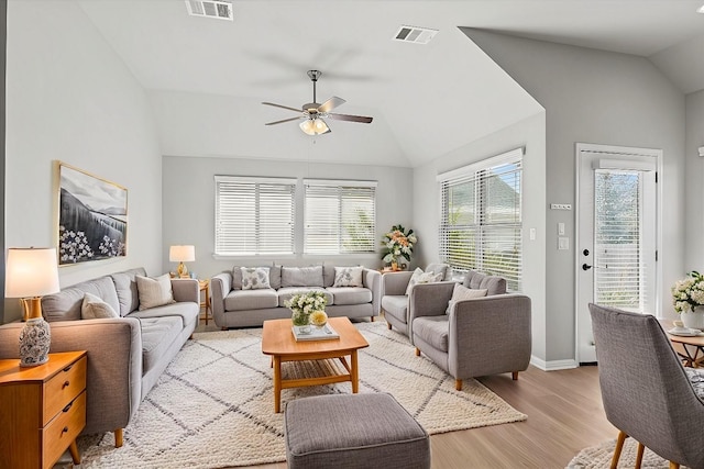 living room with ceiling fan, vaulted ceiling, and light hardwood / wood-style flooring