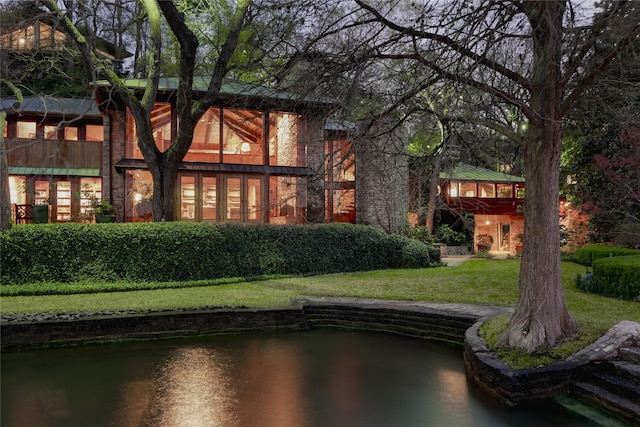 rear view of house featuring a lawn