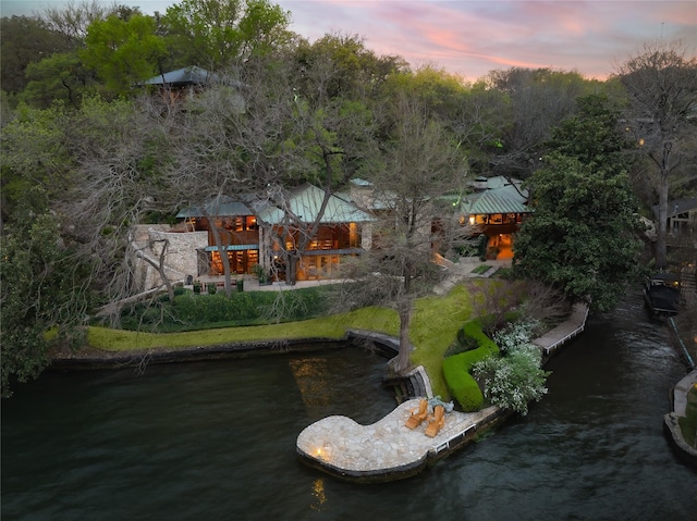 back house at dusk with a water view