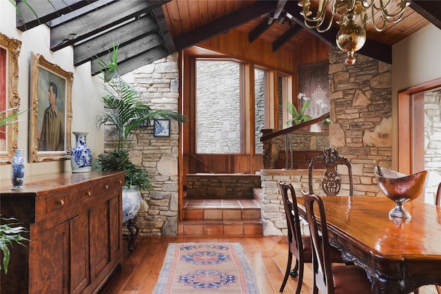 dining area with light hardwood / wood-style floors, a chandelier, wood ceiling, and vaulted ceiling with beams