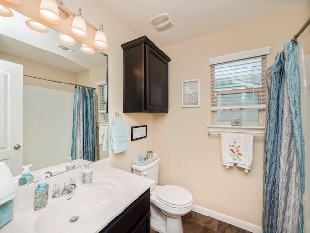 bathroom featuring toilet, vanity, and a shower with shower curtain