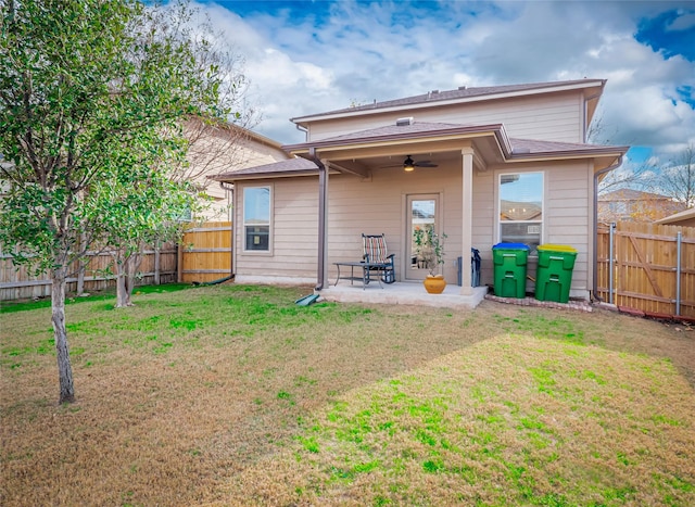 rear view of property with ceiling fan, a lawn, and a patio