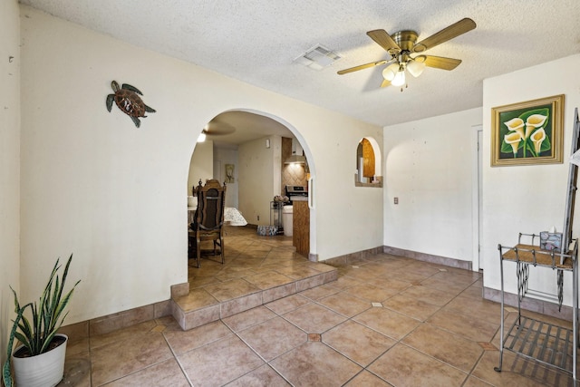 interior space with a textured ceiling and ceiling fan