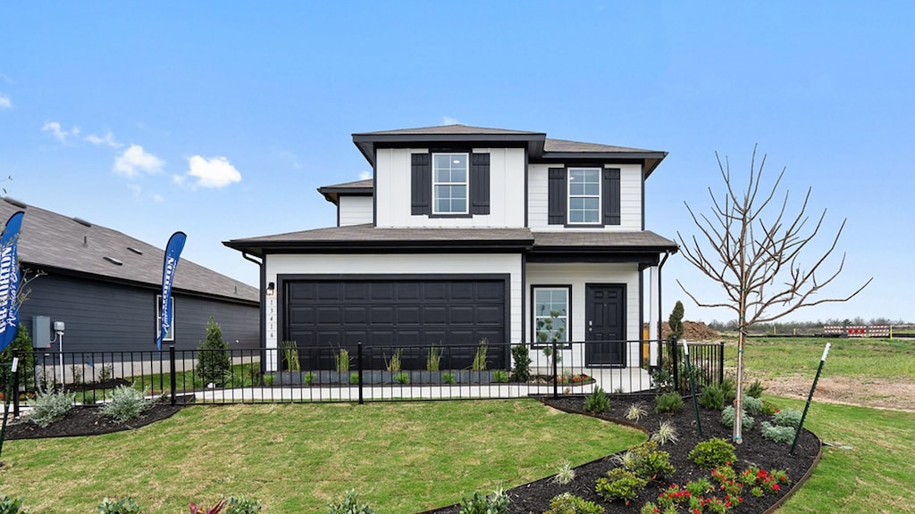 view of front of house featuring a front lawn and a garage