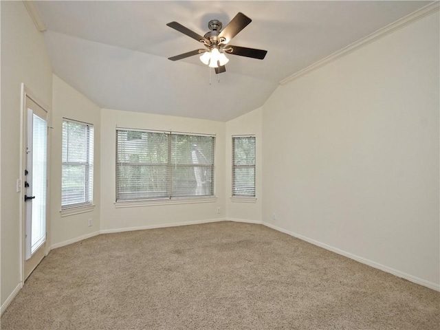 carpeted empty room featuring ceiling fan, ornamental molding, and lofted ceiling