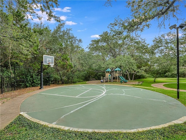 view of basketball court featuring a playground and a yard